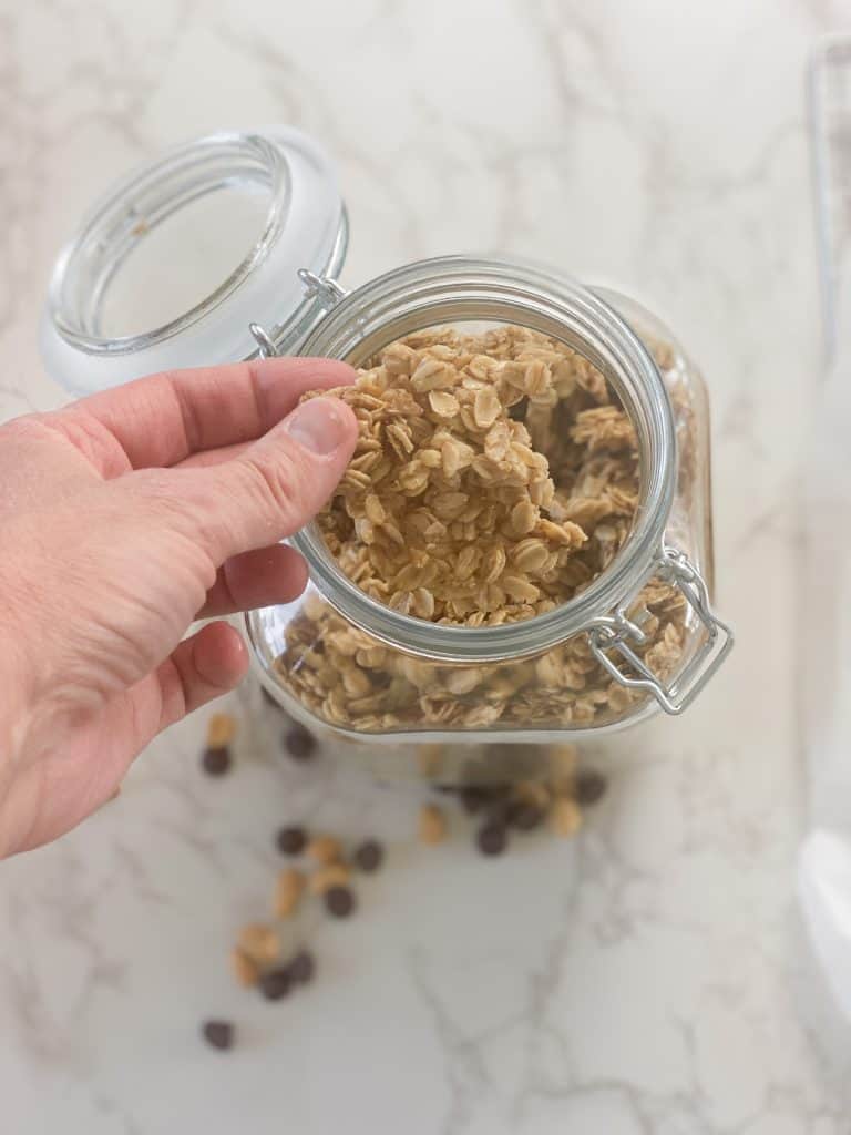 hand holding cooked granola granola in a jar