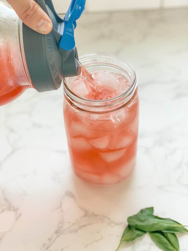 pouring herbal tea into jar