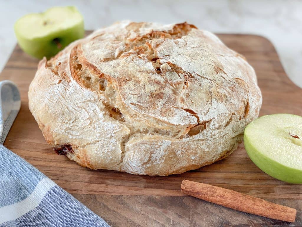 crusty sourdough apple bread artisan round with sliced apples and cinnamon stick
