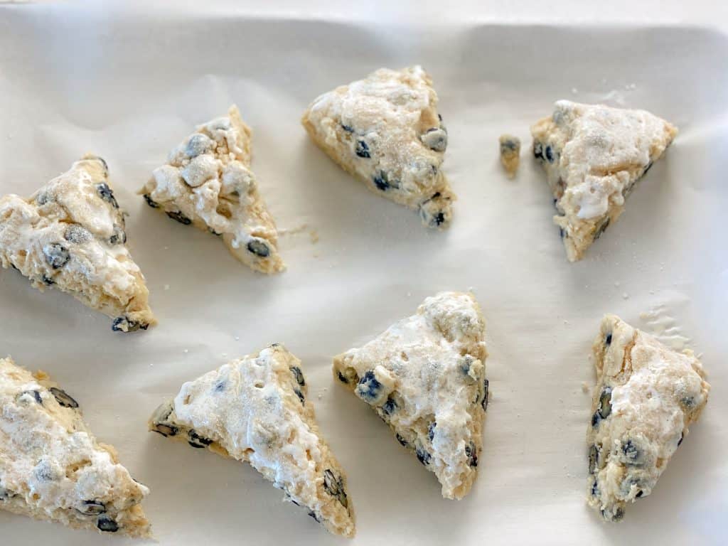 blueberry scones cut into triangles and brushed with cream and sprinkled with sugar
