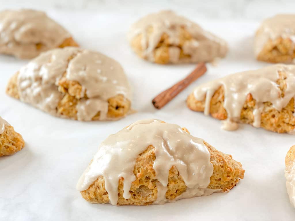 pumpkin sourdough scones with glaze sitting on a counter
