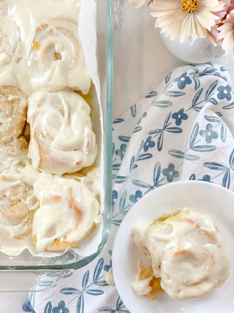 pan of orange rolls with single roll on a plate