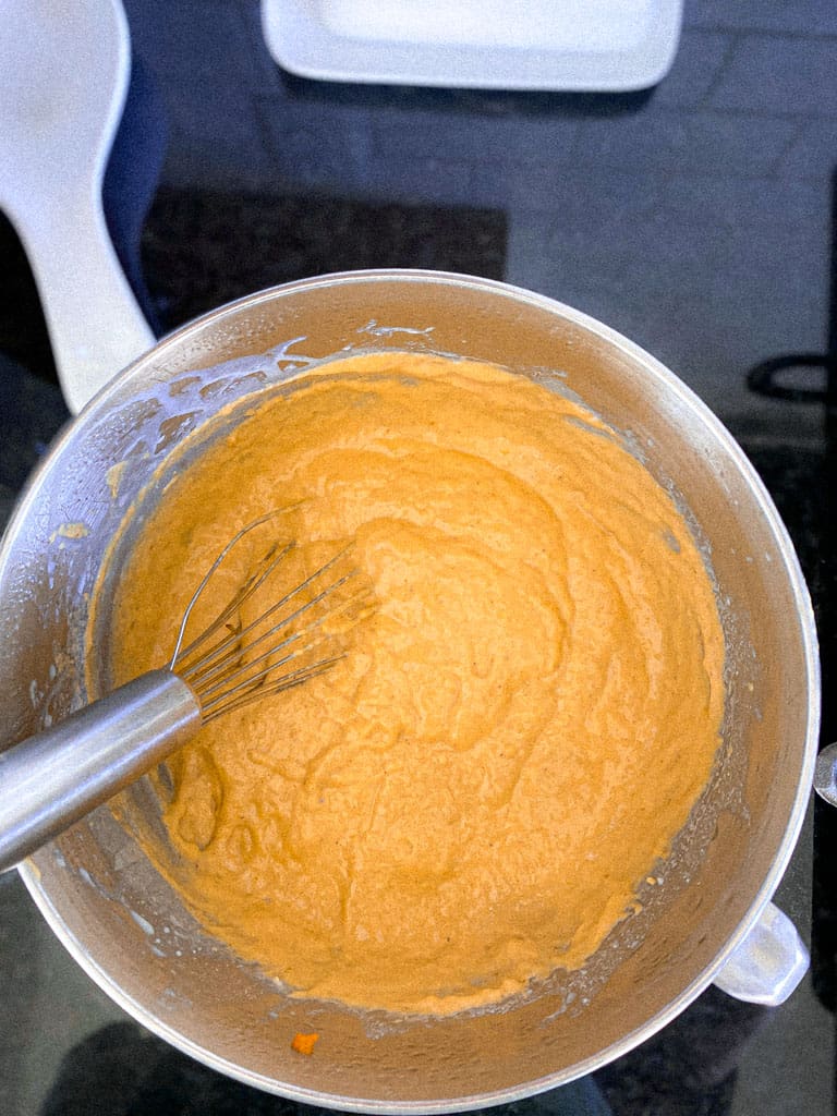 bowl of batter for pumpkin sourdough waffles with whisk