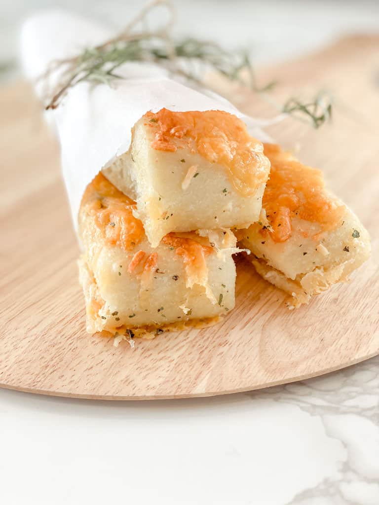 three breadsticks wrapped in parchment paper and tied with baker's twine